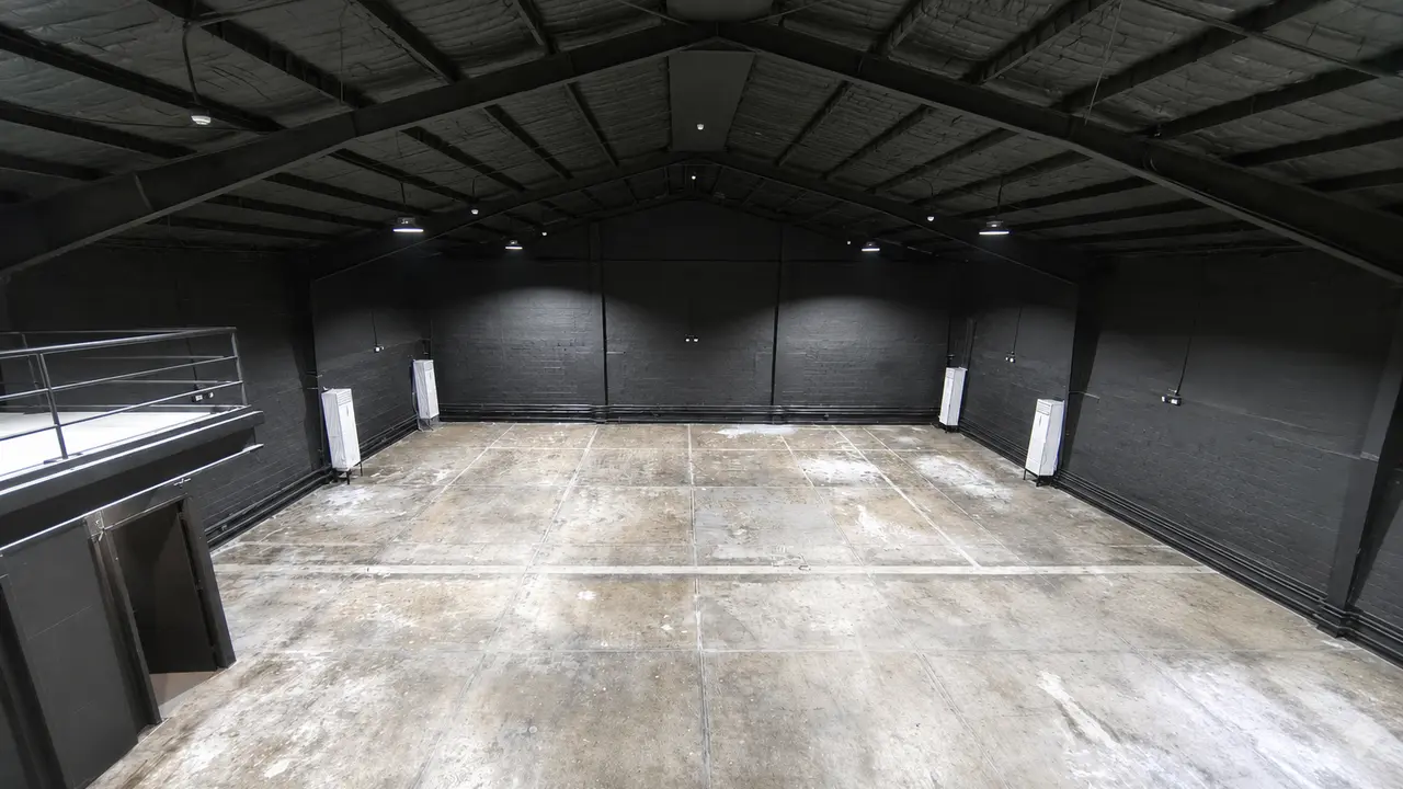 Digitally cleaned wide view across Studio W9's open matte-black industrial shell; temporary work items have been removed for planning clarity